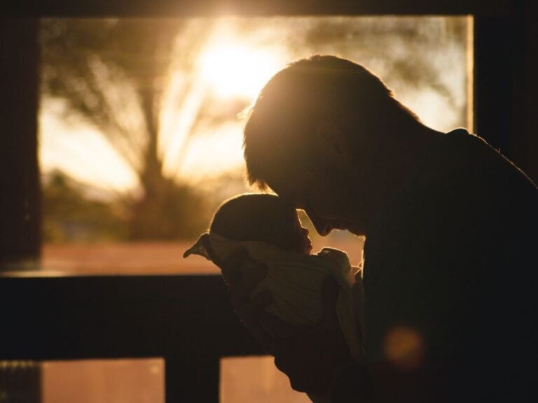 God Longs To Be Close To You Father's forehead to his baby's forehead with sunlight in background