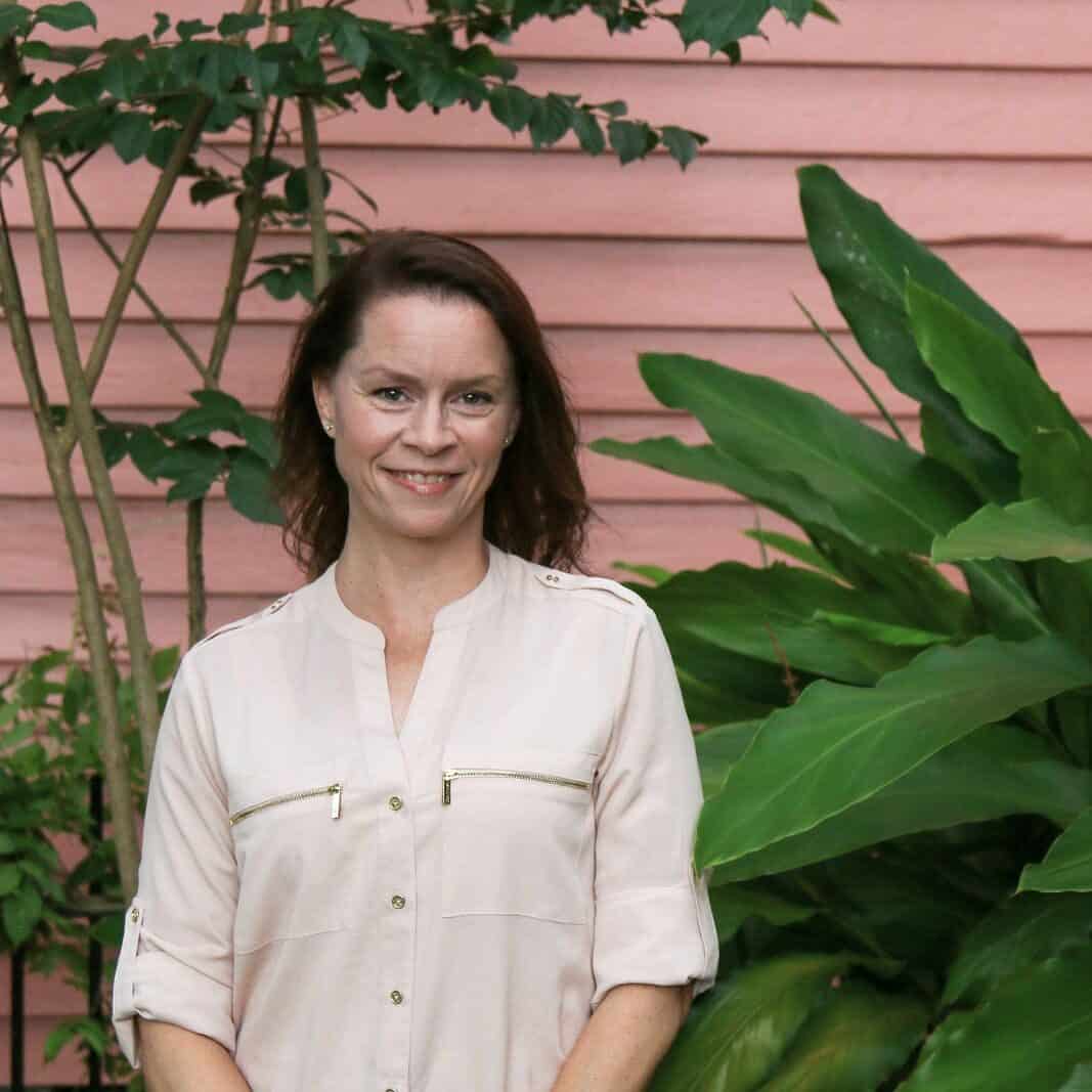 Laurie Darling Laurie Darling photo in pink shirt next to green plant.